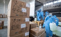 Các nhân viên và tình nguyện viên vận chuyển đồ dùng y tế tại một trung tâm triển lãm biến thành bệnh viện dã chiến ở Vũ Hán ngày 4/2. (Ảnh: CNN)