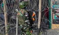 Một lính Ấn Độ đứng gác gần hàng rào dây thép gai ở Srinagar ngày 12/10. (Ảnh: AP)