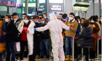 Nhân viên chặn lối ra để yêu cầu hành khách quét mã QR tại một nhà ga ở Thượng Hải ngày 25/11. (Ảnh: Reuters)