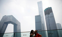 Hai phụ nữ đứng chụp ảnh trước các toà nhà cao tầng ở Bắc Kinh, Trung Quốc. (Ảnh: Reuters)