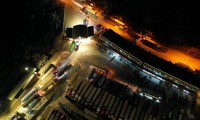 22h tối 17/12, khu vực bãi xe Tân Thanh (Lạng Sơn) vẫn sáng đèn. Hàng dài xe container nối đuôi nhau, nhích từng đoạn để được vào trong. Đây là khu vực tài xế trả hàng cho thương lái hoặc chờ thông quan để xuất khẩu nông sản sang Trung Quốc.
