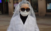  Một hành khách mặc áo nylon kín người đi bên ngoài ga tàu ở Bắc Kinh hôm 11/2ảnh: EPA-EFE 
