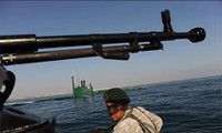 Một binh sĩ Iran đứng gác trên tàu cao tốc quân sự ở cạnh tàu ngầm trong một cuộc tập trận hải quân ở eo biển Hormuz Ảnh: Getty Images
