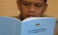 Thân nhân các nạn nhân trên chiếc MH370 đọc báo cáo về vụ tai nạn sáng 30/7. Ảnh: Malay Mail