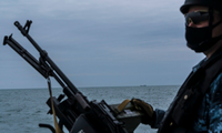 Một lính Nga tuần tra trên biển Azov ngày 19/4, cách đó không xa là một tàu của Nga. (ảnh: NYT) 