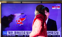 Người dân Hàn Quốc đi qua màn hình chiếu tin tức về vụ phóng tên lửa của Triều Tiên tại một ga tàu ở Seoul. (Ảnh: EPA-EFE)