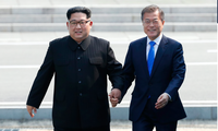 Tổng thống Hàn Quốc Moon Jae-in và Chủ tịch Triều Tiên Kim Jong Un bước qua đường phân định quân sự ở khu phi quân sự giữa hai miền vào tháng 4/2018. (Ảnh: AP)
