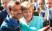 Bà Merkel chụp ảnh với một người tị nạn ở Berlin năm 2015. (Ảnh: AP)