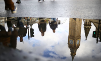 Bóng tháp đồng hồ Big Ben ở London dưới một vũng nước. (Ảnh: Reuters)