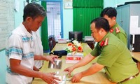 Cảnh sát trao tiền thu hồi cho ông Ba. Ảnh: Báo Long An