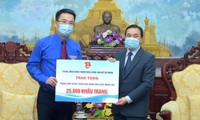 Anh Nguyễn Tường Lâm trao biển tặng 25.000 khẩu trang tới ông Seng Phết Hùng-Bun-Nhuông. Ảnh: Xuân Tùng