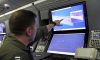 Một quân nhân Mỹ trên máy bay giám sát P-8A Poseidon xem màn hình máy tính cho thấy hoạt động xây dựng của Trung Quốc trên Đá Chữ Thập thuộc quần đảo Trường Sa của Việt Nam. Trung Quốc đã chiếm đóng và cải tạo trái phép thực thể này.