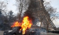 Xe quân sự chống khủng bố bị người biểu tình đốt gần Tháp Eiffel hôm 9/2. Ảnh: AFP