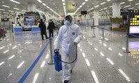 Một nhân viên phun thuốc khử trùng trong sân bay Bình Nhưỡng gần như không một bóng người (Ảnh: AP)