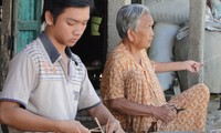 Hình ảnh em Nguyễn Thanh Nhân (8 năm trước) cùng ngoại đan lát tre mây kiếm tiền ăn học đăng trên báo Tiền Phong. Ảnh: Nguyễn Thành 
