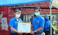 Đại diện lãnh đạo tỉnh đoàn (phải) khen thưởng, động viên Phạm Hữu Trí
