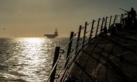 Quân nhân Mỹ trên tàu khu trục USS Bainbridge, phía xa là tàu sân bay USS Abraham Lincoln trên eo biển Gibralta ngày 13/4 ảnh: Reuters/Sputnik