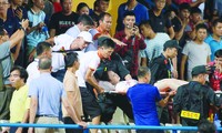 Nữ cổ động viên được đưa lên cáng đi cấp cứu sau khi bị trúng pháo sáng vào đùiảnh: VSI