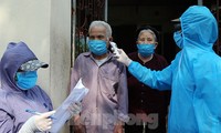 Cán bộ y tế đến từng nhà dân ở thôn Hạ Lôi, Mê Linh, Hà Nội đo thân nhiệt và ghi nhận tình hình sức khỏe từng người dân. Ảnh: Mạnh Thắng