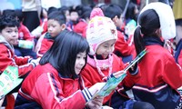 Các em học sinh trường Tiểu học Dịch vọng A dang đọc các thông tin về phân loại rác thải, bảo vệ môi trường