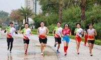 Chị Nguyệt Hằng (áo đỏ)- nhất cự ly half marathon 21km nhóm tuổi trên 45 tại Tiền Phong Marathon 2021
