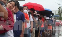 Người dân tỉnh Bắc Ninh xếp hàng dưới mưa để vào trong sân thi đấu cổ vũ cho các vận động viên quần vợt Việt Nam