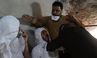 Hai người đàn ông được chăm sóc y tế, thở bằng mặt nạ oxy tại hiện trường vụ tấn công bằng vũ khí hóa học ở Idlib hôm 4/4. Ảnh: Reuters