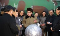 Chủ tịch Triều Tiên Kim Jong-un (giữa) nói chuyện về các nhà khoa học và chuyên viên kĩ thuật về mô hình đầu đạn hạt nhân, được Bình Nhưỡng gọi là "quả cầu disco". Ảnh: KCNA