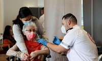 Một cụ bà Israel được tiêm vắc xin ở Netanya. Ảnh: Reuters