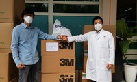 Đại diện Báo Tiền Phong tại TPHCM (trái) tặng đồ bảo hộ khẩu trang cho Bệnh viện Nhân Dân 115