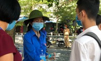 Thanh niên tienhf nguyện Thái Bình giúp thí sinh khử khuẩn trước khi vào phòng thi - Ảnh: Hoàng Long