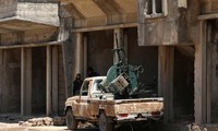 2 tay súng của Quân đội Syria Tự do nghỉ ngơi bên khẩu súng máy chống máy bay ở Quneitra, Syria. Ảnh: Reuters