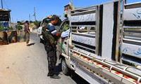 Các tay súng của liên minh các nhóm nổi dậy Jaish al Fateh kiểm tra xe tải tại tỉnh Idlib hôm 18/7. Ảnh: Reuters