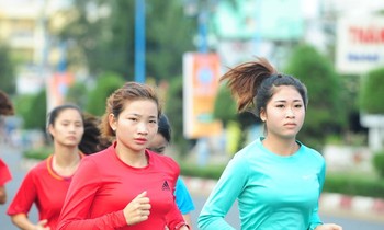 Nguyễn Thị Oanh (áo đỏ) rèn luyện để tranh tài trên đường chạy báo Tiền Phong. (Trong ảnh, Oanh chuẩn bị thi tài giải năm 2019). Ảnh: Xuân Tùng