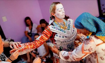 Bà Aziza Sefitagic giúp Sellma Demirovic mặc váy cưới sau khi vẽ mặt xong cho cô dâu