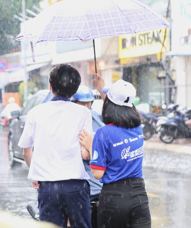 Tình nguyện viên đội mưa che ô cho thí sinh và phụ huynh ảnh 8