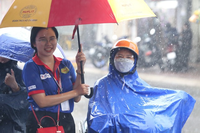 Tình nguyện viên đội mưa che ô cho thí sinh và phụ huynh ảnh 9