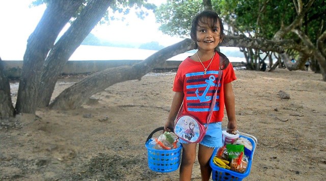 Bé gái 5 tuổi nói 4 thứ tiếng bán đồ ăn cho khách nước ngoài trên bãi biển ảnh 1