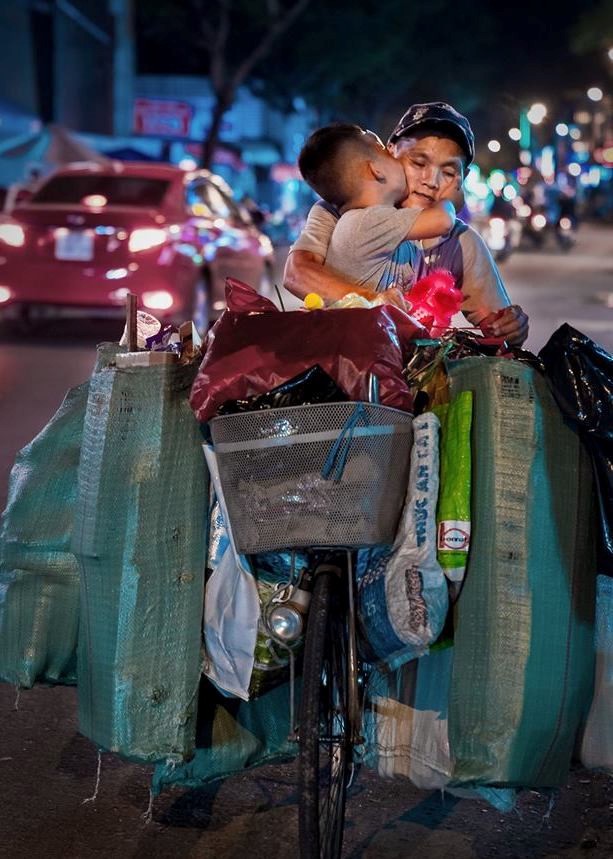 Cậu bé hôn mẹ trên chiếc xe chở đầy ve chai ảnh 1