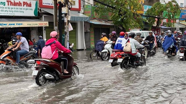 Người dân Sài Gòn di chuyển vất vả trên những con đường ngập đầy nước sau trận bão ảnh 4