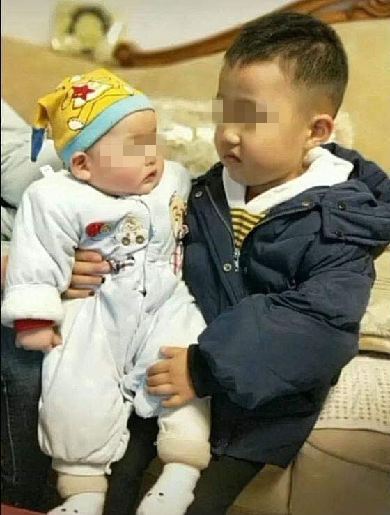 Vẻ mặt ngán ngẩm của cậu bé khi phải bế em khiến cư dân mạng thích thú ảnh 2