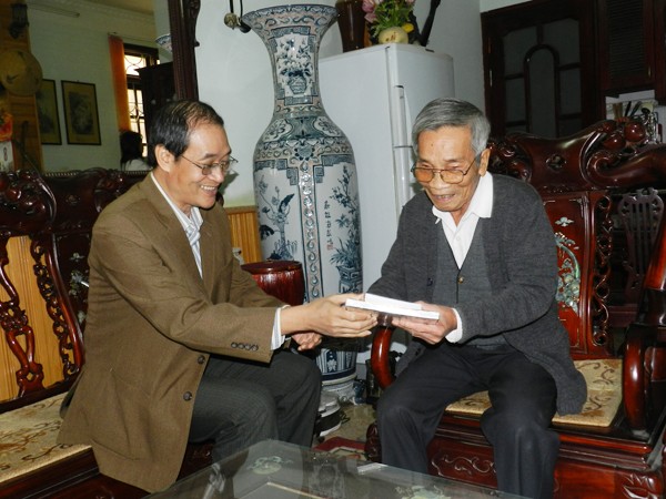 Tác giả bài viết trao tặng ông Trần Bình Lục một số ấn phẩm có trích đăng tiểu thuyết Truyện anh Lục, trong lần đến thăm ông tại nhà một người con