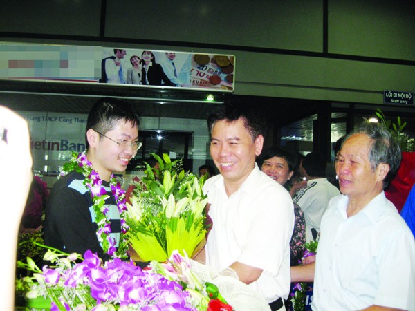 Thày Nguyễn Đức Hoàng chúc mừng Đậu Hải Đăng (trái) tại sân bay Nội Bài. Người ngoài cùng bên phải là bố của Đăng Ảnh: Quý Hiên