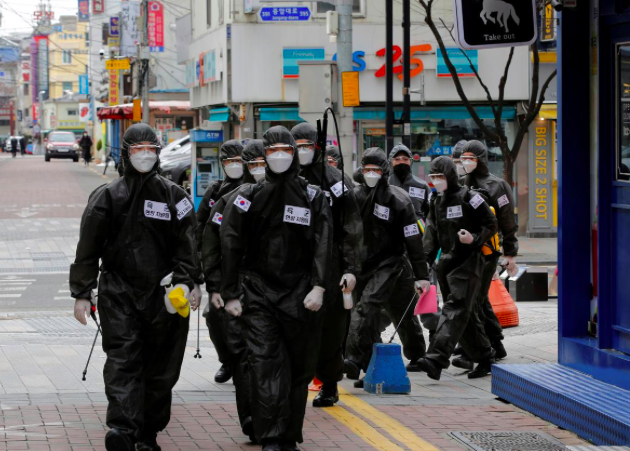 Nhóm binh lính Hàn Quốc đi khử trùng các toà nhà. (Ảnh: Reuters)