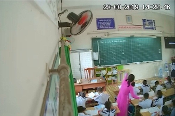 Cô giáo đang véo tai một học sinh
