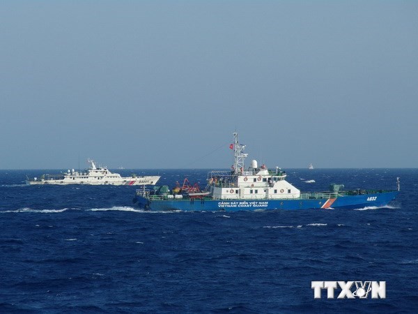 Tàu hải cảnh Trung Quốc (trái) đeo bám, ngăn cản quyết liệt tàu cảnh sát biển Việt Nam đang làm nhiệm vụ. (Ảnh: Công Định/Hữu Trung/TTXVN) 