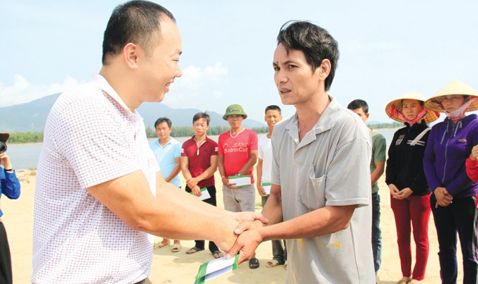 Ông Ngô Tuấn Toàn, đại diện lãnh đạo Cty Cổ phần Tập đoàn Phúc Sơn trao quà cho ngư dân bị hư hại tàu cá. Ảnh: Trường Phong.