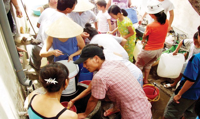 Người dân Định Công, Hà Nội chen nhau hứng nước sạch từ xe bồn chở đến trong những ngày mất nước. Ảnh: Hồng Vĩnh.