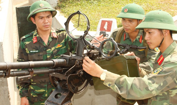 Thượng uý Đặng Quang Trung (ngoài cùng bên trái) hướng dẫn các pháo thủ bắn súng máy phòng không 12,7mm.