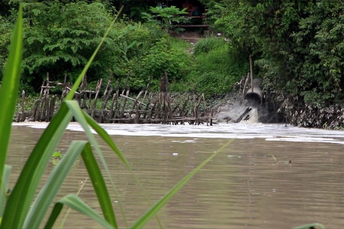 Một ống xả thải của nhà máy giấy đổ ra sông Thị Tính.